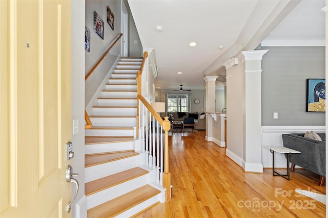 foyer with decorative columns, stairway, light wood-style flooring, and ornamental molding