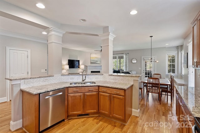 kitchen featuring a fireplace, a sink, open floor plan, dishwasher, and brown cabinetry