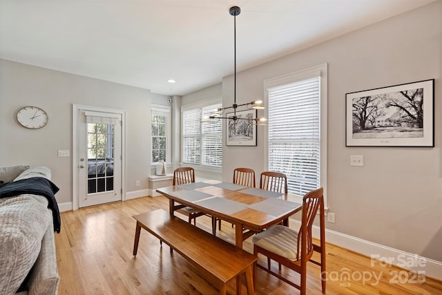 dining area with a notable chandelier, light wood-type flooring, and baseboards