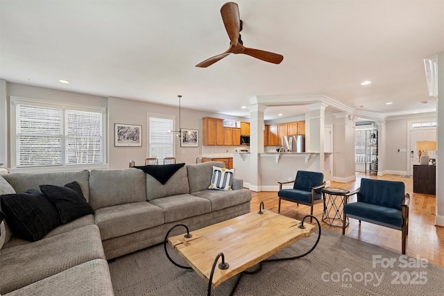 living room with light wood-style floors, ceiling fan, ornate columns, and recessed lighting
