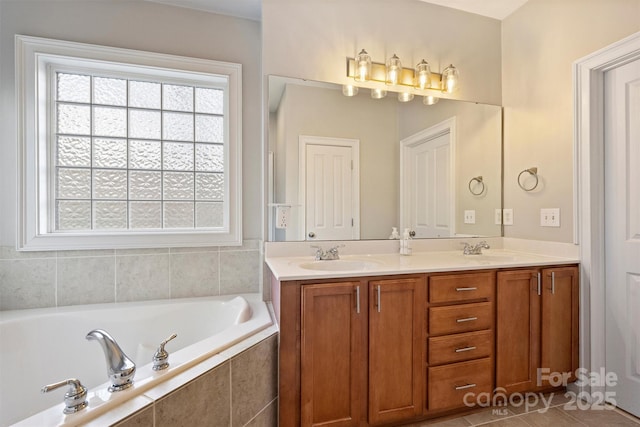 bathroom with double vanity, tile patterned flooring, a sink, and a bath