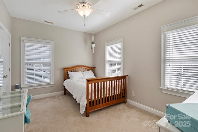 bedroom with baseboards, visible vents, and light colored carpet