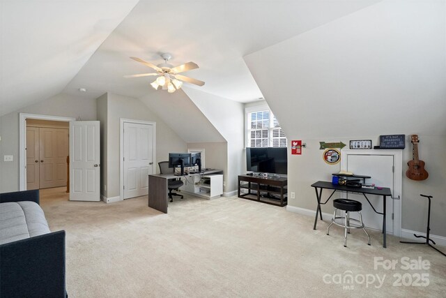 carpeted office with lofted ceiling, ceiling fan, and baseboards