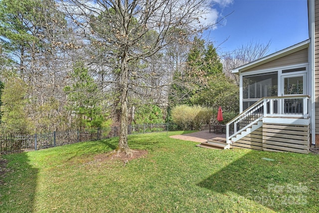 view of yard featuring a sunroom and a fenced backyard