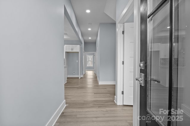 corridor with light wood-style floors, recessed lighting, and baseboards