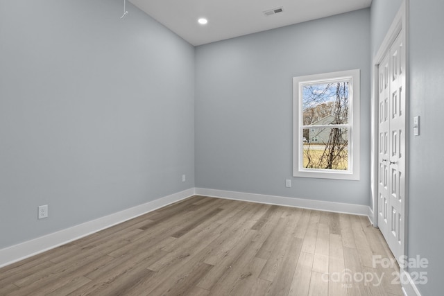 empty room featuring light wood-style flooring, recessed lighting, visible vents, and baseboards