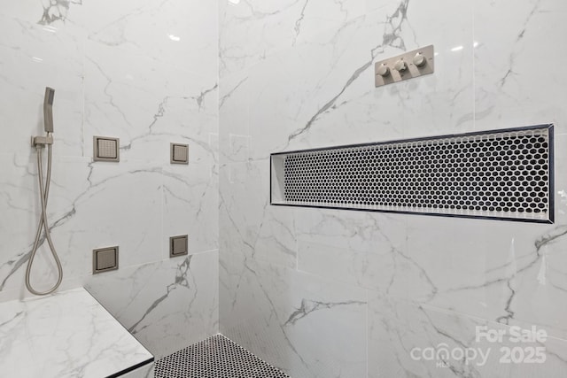 bathroom with visible vents and a marble finish shower