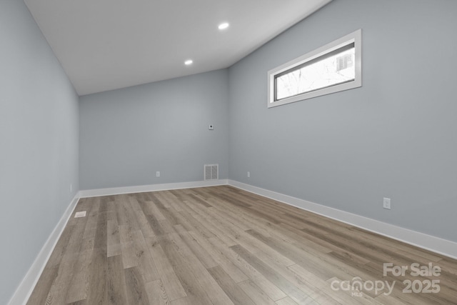 spare room featuring light wood finished floors, recessed lighting, visible vents, and baseboards