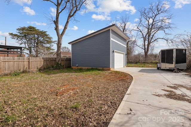 view of side of property with a garage, an outdoor structure, and fence