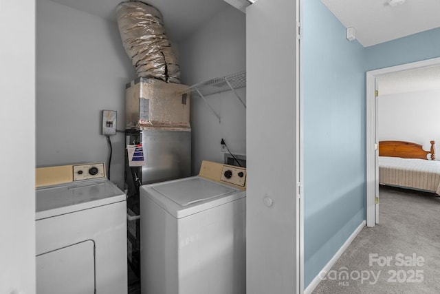 laundry room with laundry area, baseboards, separate washer and dryer, and light colored carpet