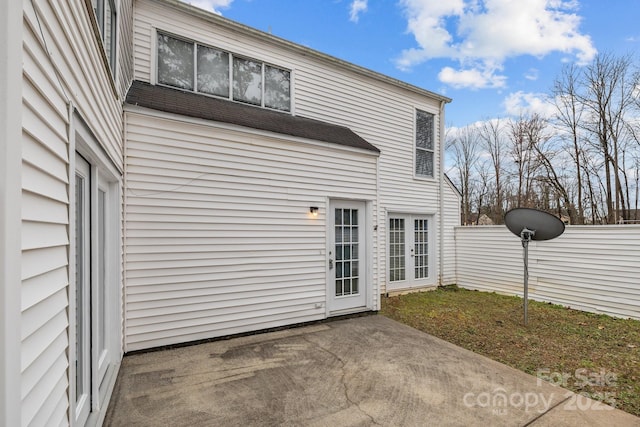 rear view of property with a patio, french doors, and fence