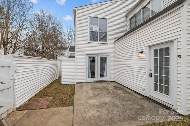 back of property with fence and a patio