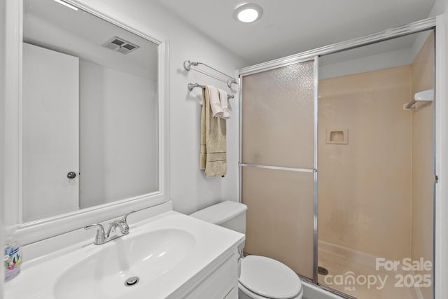 full bath with toilet, a stall shower, vanity, and visible vents