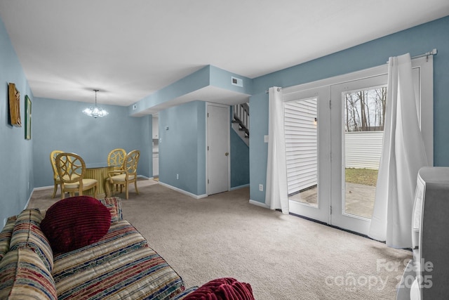 living area featuring a chandelier, carpet flooring, visible vents, and baseboards