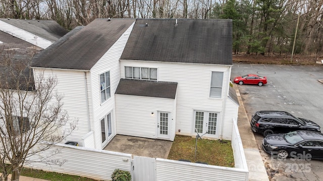 back of house featuring a shingled roof and fence