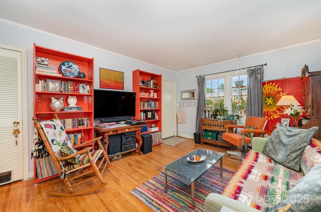 living area featuring ornamental molding and wood finished floors