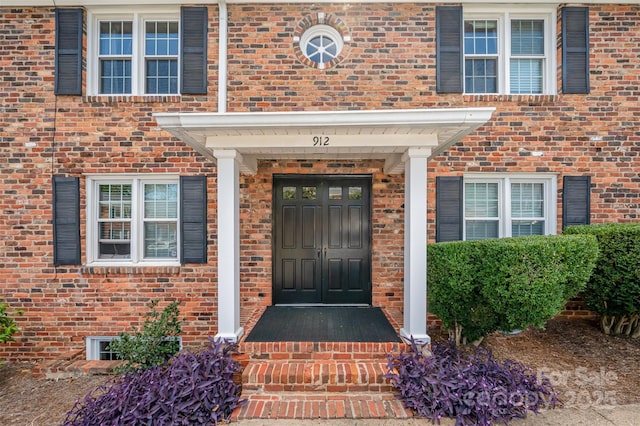 view of exterior entry featuring brick siding