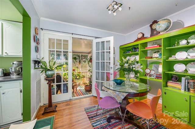 interior space with visible vents, crown molding, and wood finished floors