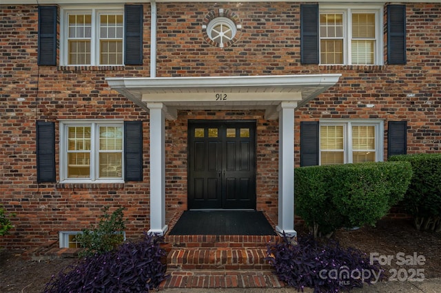 doorway to property with brick siding