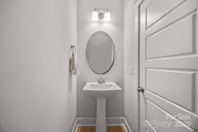 bathroom with baseboards and wood finished floors