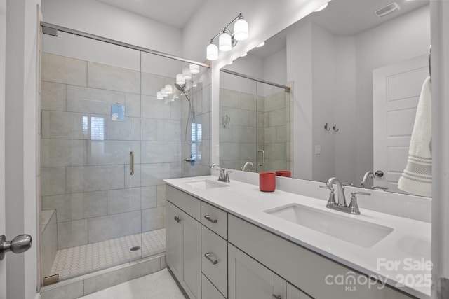 bathroom with a sink, visible vents, double vanity, and a shower stall