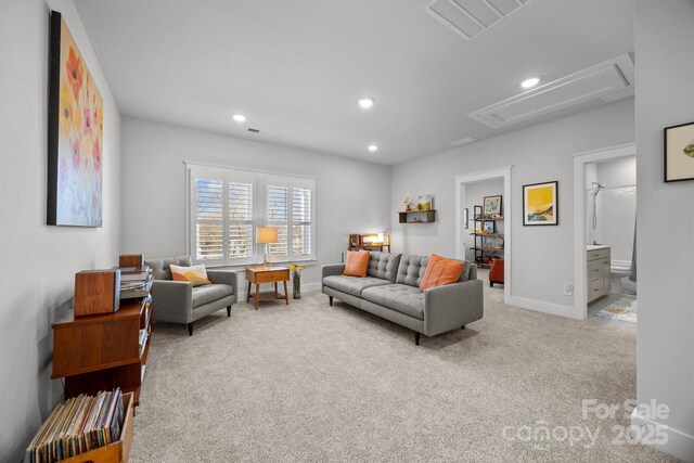 carpeted living area with recessed lighting, visible vents, baseboards, and attic access