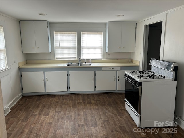 kitchen with dark wood-style flooring, a sink, visible vents, light countertops, and white gas range