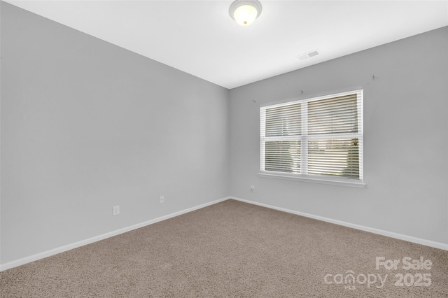 carpeted empty room with visible vents and baseboards