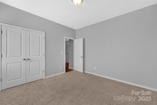 unfurnished bedroom with carpet, baseboards, and a closet