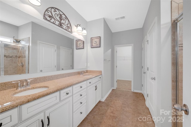 bathroom featuring a stall shower, visible vents, and a sink