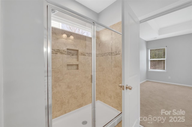 bathroom featuring a stall shower, a healthy amount of sunlight, and baseboards