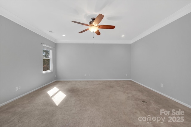 carpeted spare room featuring a ceiling fan, visible vents, crown molding, and baseboards