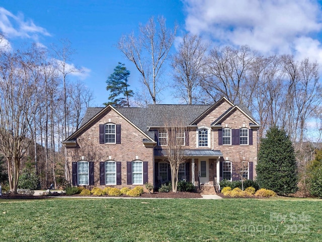 view of front of home with a front yard and brick siding