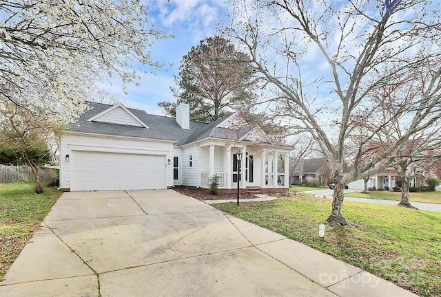 view of front of house featuring a porch, concrete driveway, a front yard, a chimney, and a garage