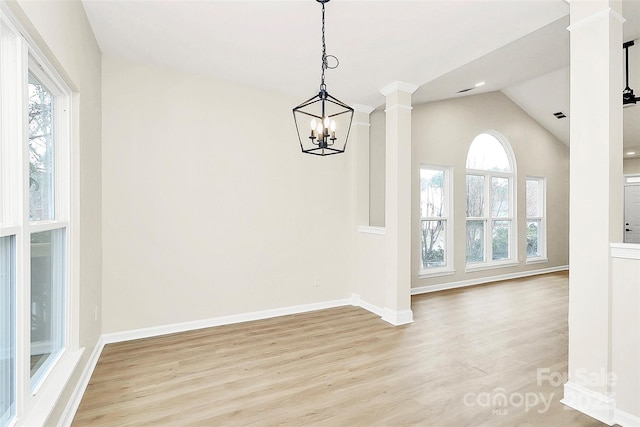 unfurnished dining area with a wealth of natural light, light wood finished floors, baseboards, and decorative columns