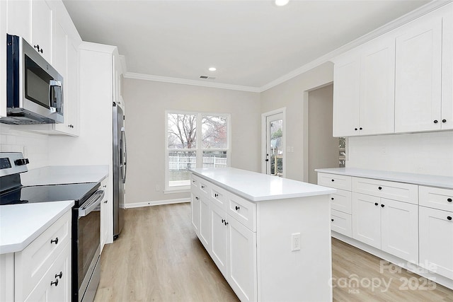 kitchen with visible vents, backsplash, a kitchen island, appliances with stainless steel finishes, and crown molding