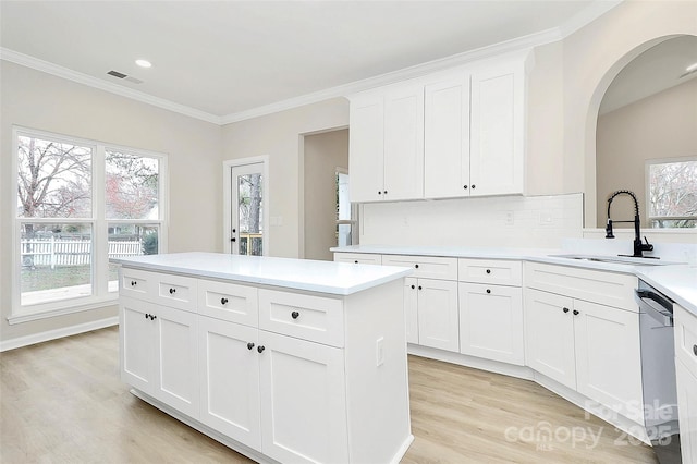 kitchen featuring visible vents, dishwasher, light countertops, light wood-type flooring, and a sink