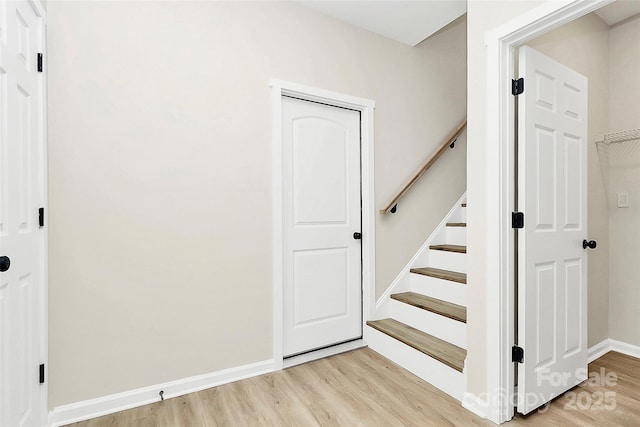 stairway featuring baseboards and wood finished floors