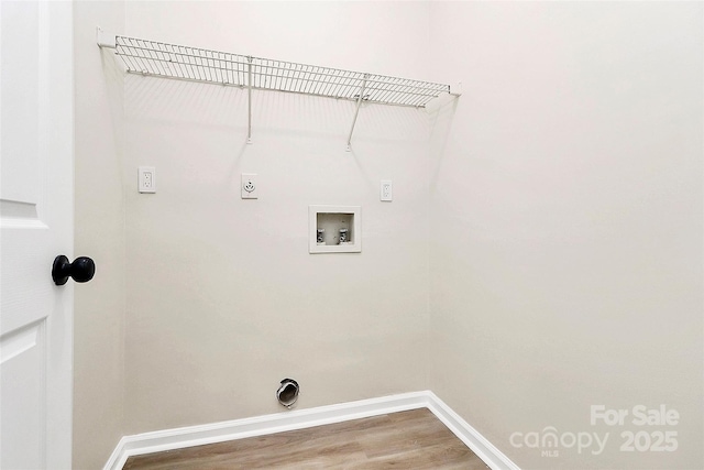 clothes washing area featuring baseboards, washer hookup, laundry area, wood finished floors, and hookup for an electric dryer