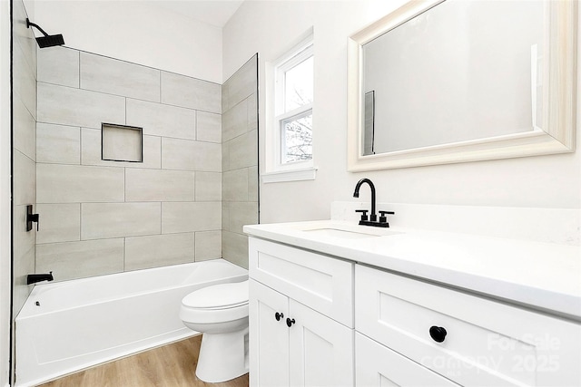 bathroom with bathtub / shower combination, toilet, wood finished floors, and vanity