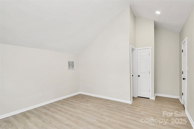 bonus room featuring visible vents, light wood-style flooring, baseboards, and vaulted ceiling