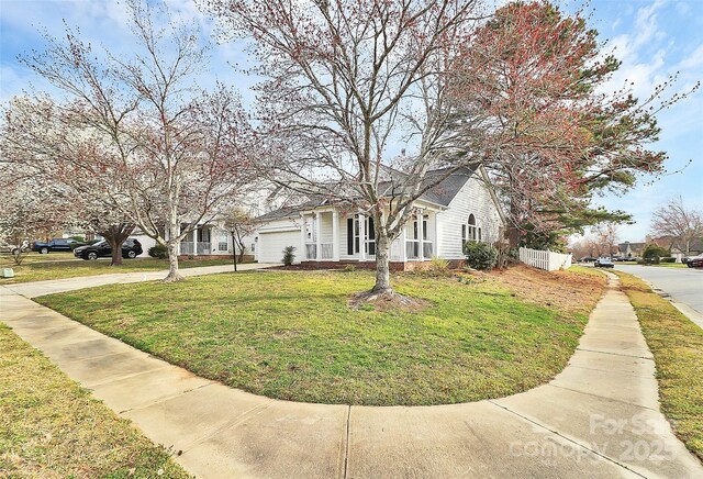 view of front of property featuring driveway, an attached garage, and a front yard