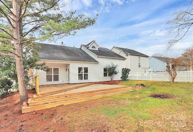 back of house with a lawn, a wooden deck, and fence