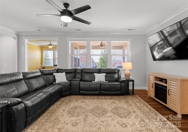 living room featuring dark wood finished floors, visible vents, and ornamental molding