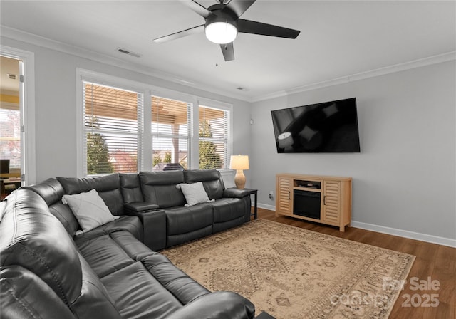 living room featuring visible vents, a wealth of natural light, and ornamental molding