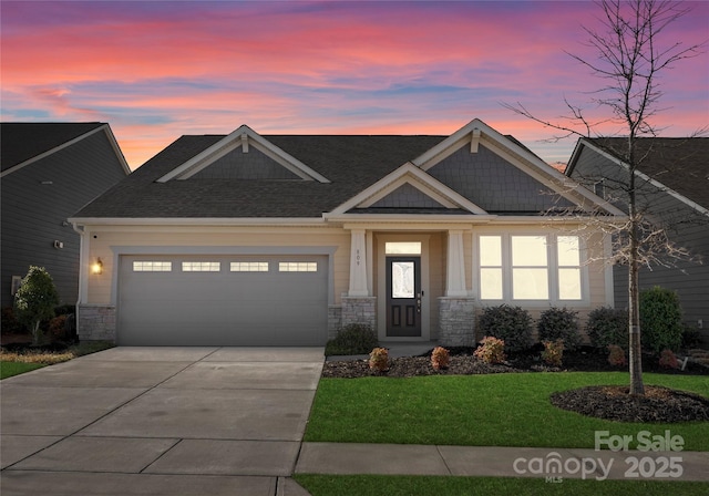 craftsman-style home with a garage, stone siding, a front lawn, and driveway