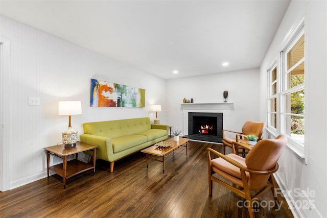 living area featuring recessed lighting, a brick fireplace, baseboards, and wood finished floors