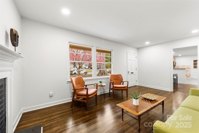 living area featuring recessed lighting, a fireplace, baseboards, and wood finished floors