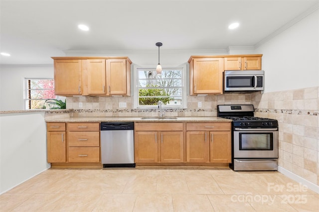 kitchen with appliances with stainless steel finishes, a wealth of natural light, crown molding, and a sink