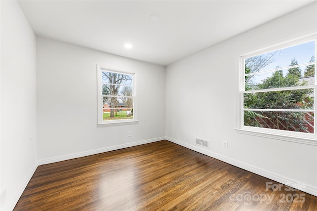 empty room featuring recessed lighting, visible vents, baseboards, and wood finished floors